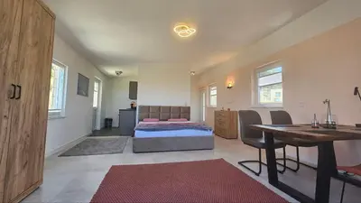 a bedroom with a bed and a table and a desk at Panorama Suite in Dobra Voda