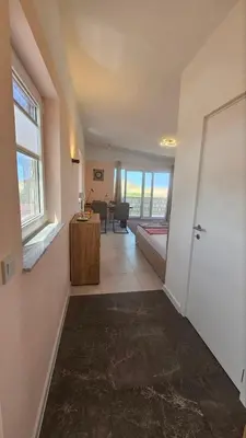 a room with a hallway with a door and a living room at Panorama Suite in Dobra Voda