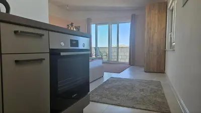 a kitchen with a black stove top oven next to a door at Panorama Suite in Dobra Voda