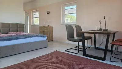 a bedroom with a bed and a table and a desk at Panorama Suite in Dobra Voda