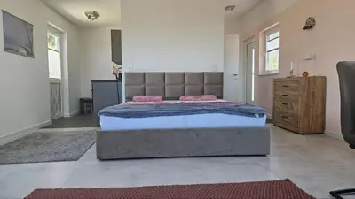 a bedroom with a large bed with pink pillows on it at Panorama Suite in Dobra Voda