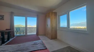 a bedroom with large windows with a view of the mountains at Panorama Suite in Dobra Voda