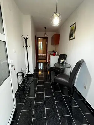 a room with a black tiled floor with a table and a chair at Krsto in Budva