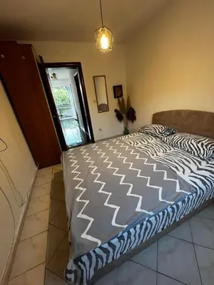 a large bed in a room with a zebra blanket at Krsto in Budva