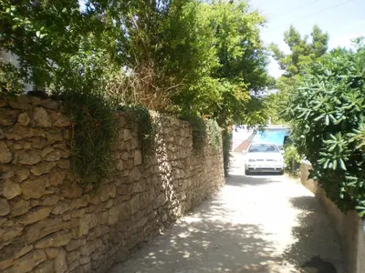 a car driving down a road next to a stone wall at Apartment Vuk i Novak in Ulcinj