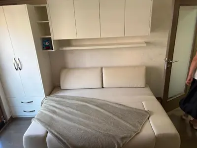 a small bedroom with a bed with a blanket on it at Njaro Del Mar Studio 13 in Petrovac na Moru