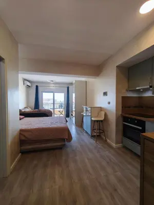 a bedroom with a bed and a kitchen in a room at Sea & Sand Apartment in Bar