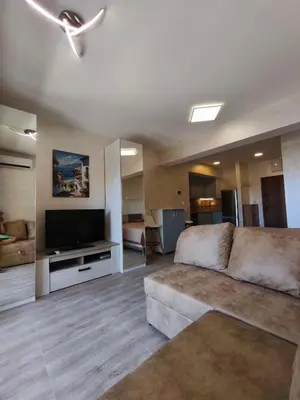 a living room with a couch and a flat screen tv at Sea & Sand Apartment in Bar