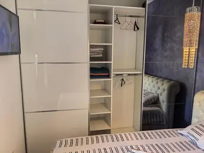 a walk in closet with a mirror and a bed at City View 7 - Budva Center in Budva
