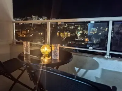 a table on a balcony with a view of a city at City View 7 - Budva Center in Budva