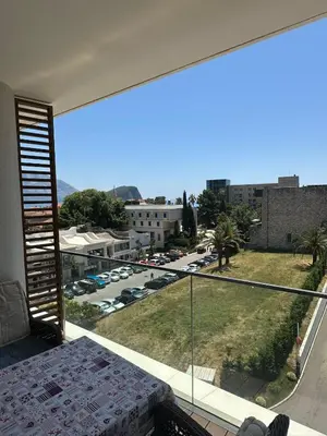 a room with a balcony with a view of a parking lot at Dukley Residence Budva Old Town in Budva