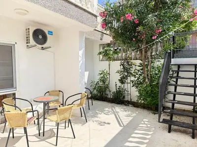 a patio with chairs and a table and a tree at Sutomore Two Bedroom Apartment in Sutomore