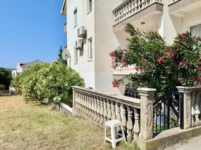 a white stool sitting on the side of a house at Sutomore Two Bedroom Apartment in Sutomore