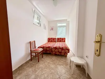 a small bedroom with a bed and a chair at Sutomore Two Bedroom Apartment in Sutomore