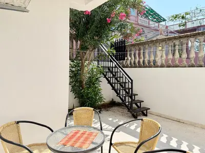 a patio with a table and chairs and a staircase at Sutomore Two Bedroom Apartment in Sutomore