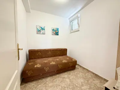 a brown couch sitting in a corner of a room at Sutomore Two Bedroom Apartment in Sutomore