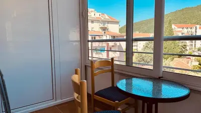 a table and a chair in a room with a window at Budva Summer House in Budva