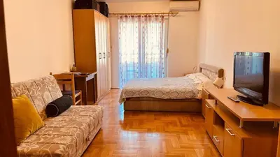 a living room with a bed and a couch and a television at Budva Summer House in Budva