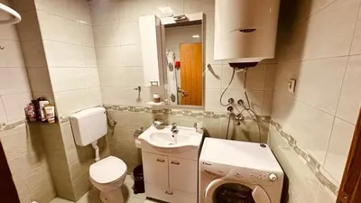a bathroom with a sink and a washing machine at Budva Summer House in Budva