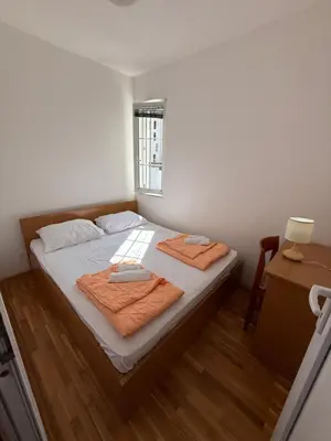 a bedroom with a bed with two towels on it at Jadran Rafailovic in Rafailovici