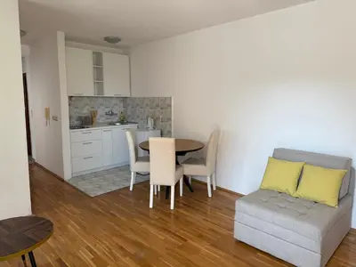 a kitchen and dining room with a table and a couch at Jadran Rafailovic in Rafailovici