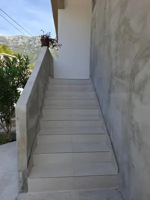 a staircase leading up to a house with a potted plant at Apartmani Šćekić in Bar