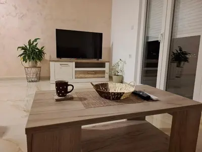a living room with a coffee table with a television at Apartmani Šćekić in Bar