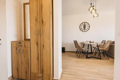 a dining room with a wooden cabinet and a table at SeaSide Luxury Apartments in Ulcinj