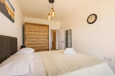a bedroom with a bed with a clock on the wall at SeaSide Luxury Apartments in Ulcinj