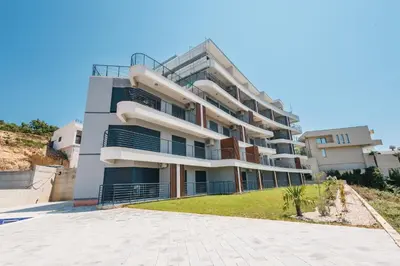 a large apartment building with a lawn in front of it at SeaSide Luxury Apartments in Ulcinj
