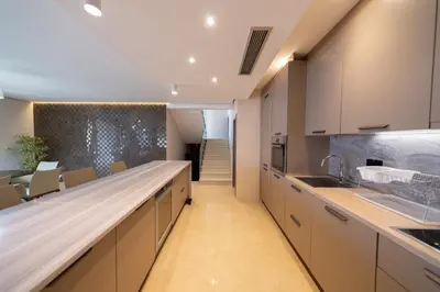 a kitchen with white cabinets and a long counter at Villa Patria in Budva