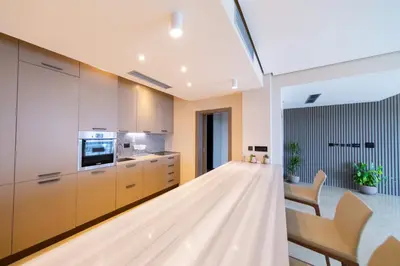 a kitchen with white cabinets and a table and chairs at Villa Patria in Budva