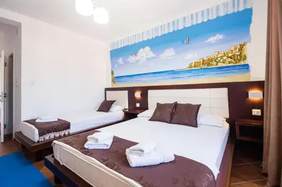 two beds in a room with a painting on the wall at Apartments FourRoses in Ulcinj