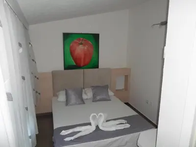 a bedroom with a bed with a painting of an apple at Apartments FourRoses in Ulcinj