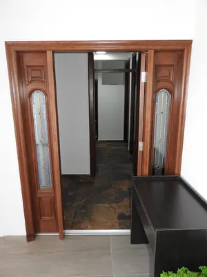 a hallway with a wooden door and a mirror at Apartments FourRoses in Ulcinj