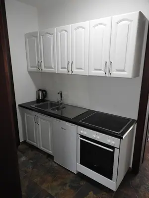 a kitchen with white cabinets and a sink at Apartments FourRoses in Ulcinj