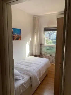 a bedroom with a white bed and a window at Apartman Budva Centar in Budva