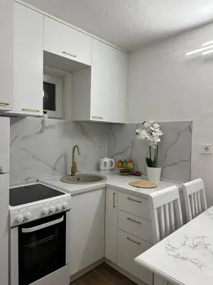 a white kitchen with a sink and a stove at Apartman Budva Centar in Budva