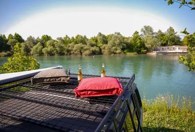 two bottles of beer sitting on a table next to a river at Camperlife Montenegro in Podgorica