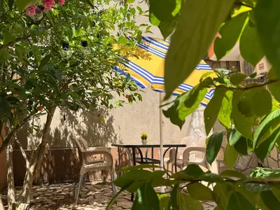 a patio with a table and chairs and an umbrella at Apartment Sara in Petrovac na Moru