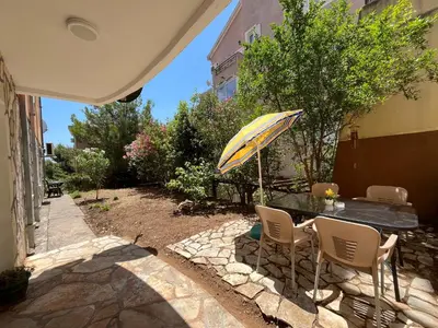 a table and chairs with an umbrella on a patio at Apartment Sara in Petrovac na Moru