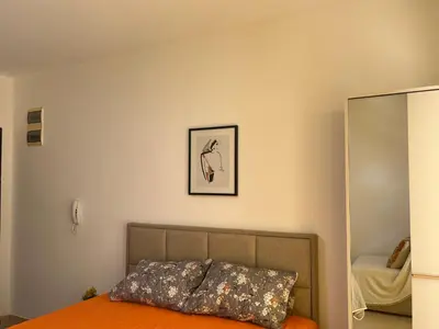 a bedroom with a bed and a mirror at Apartment Sara in Petrovac na Moru