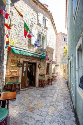 an alley with tables and chairs in a building at Charming Apartment in The Old Town in Budva