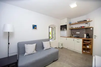 a living room with a couch and a kitchen at Charming Apartment in The Old Town in Budva