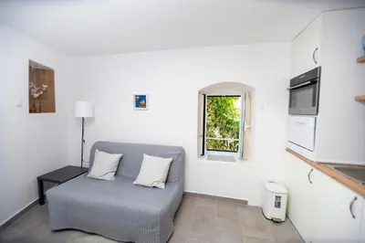 a living room with a couch and a window at Charming Apartment in The Old Town in Budva