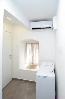 a white kitchen with a refrigerator and a window at Charming Apartment in The Old Town in Budva