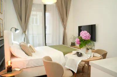a bedroom with a bed and a table with flowers on it at Helen studio apartment in Kotor