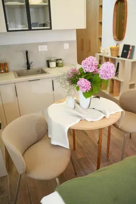 a table with a vase of pink flowers on it at Helen studio apartment in Kotor