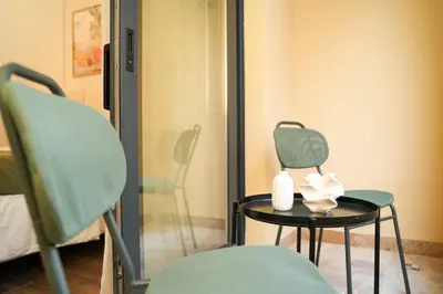 a green chair and a table with a lamp at Helen studio apartment in Kotor