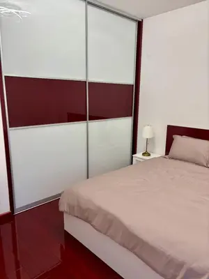 a bedroom with a white bed and glass walls at Mia Bella in Bar